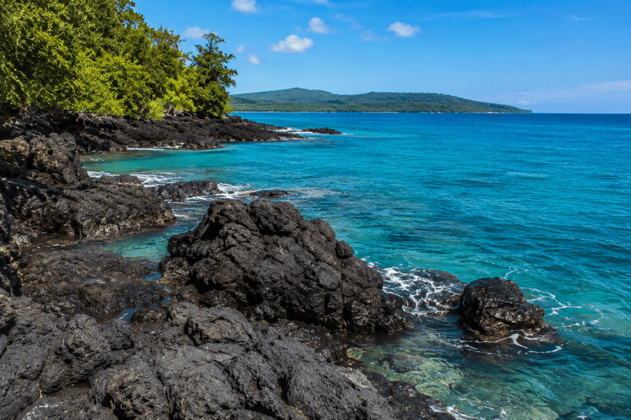 Black rock formations along the shoreline